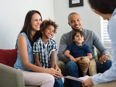 Diverse family of 4 talking with councelor at home